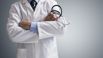 doctor holding a stethoscope with arms crossed. image being used to illustrate how important it is to know what is important to your hospital when choosing a locum tenens hospitalist and why you should work with sonoran hospital medicine, plc, scottsdale's locum tenens hospitalist practice